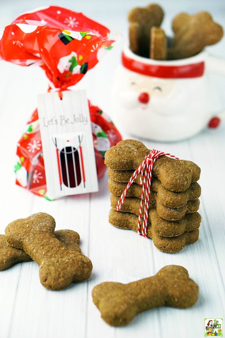 Homemade dog biscuits and treats in a Santa mug, wrapped in string, and in a gift bag.