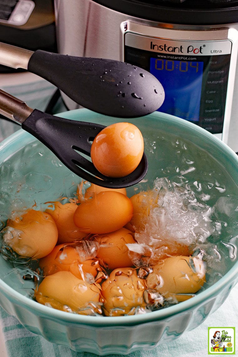 Placing hot hard boiled eggs in an ice water bath with tongs.