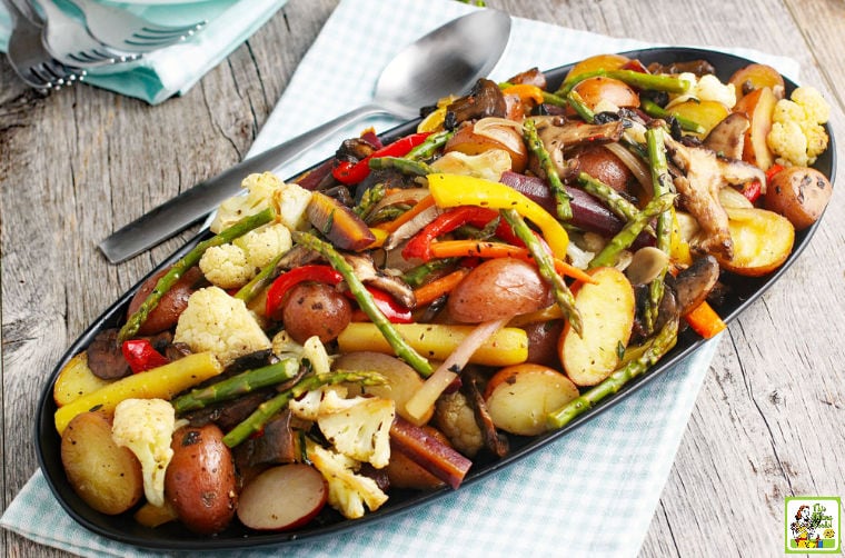 A platter of Oven Roasted Vegetables with serving spoon, forks, and napkins.
