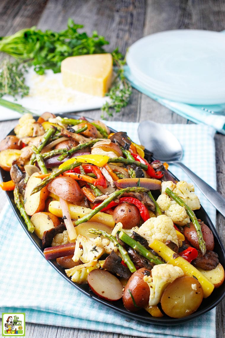 A platter of oven roasted veggies like potatoes, asparagus, cauliflower, and bell peppers.