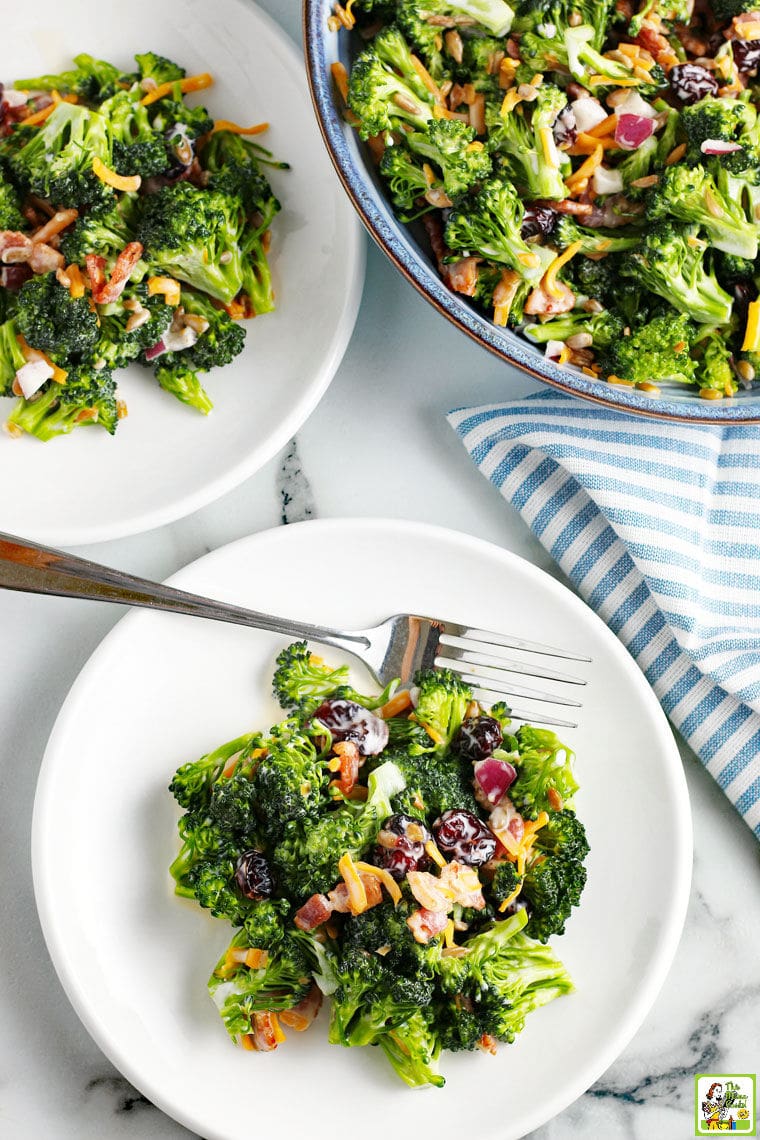 Broccoli Bacon Salad on white plates and in a blue bowl with blue and white napkin.