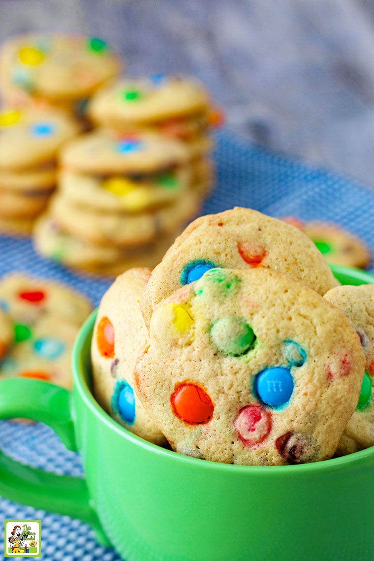 Closeup of a green mug filled with M&M Chocolate Chip Cookies