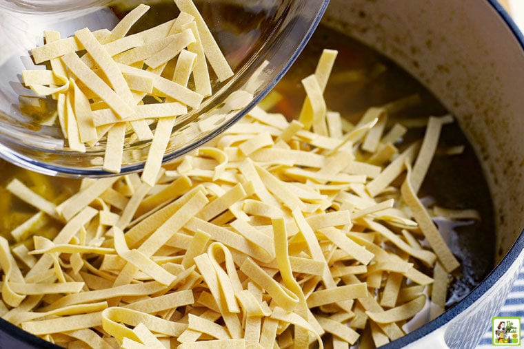 Adding egg noodles to the pot of Leftover Turkey Soup recipe.