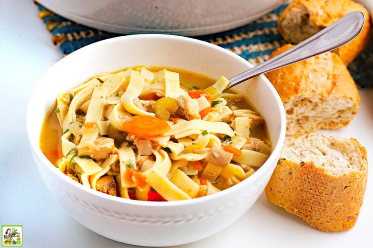 A bowl of Leftover Turkey Soup with spoon and pieces of crusty French bread.