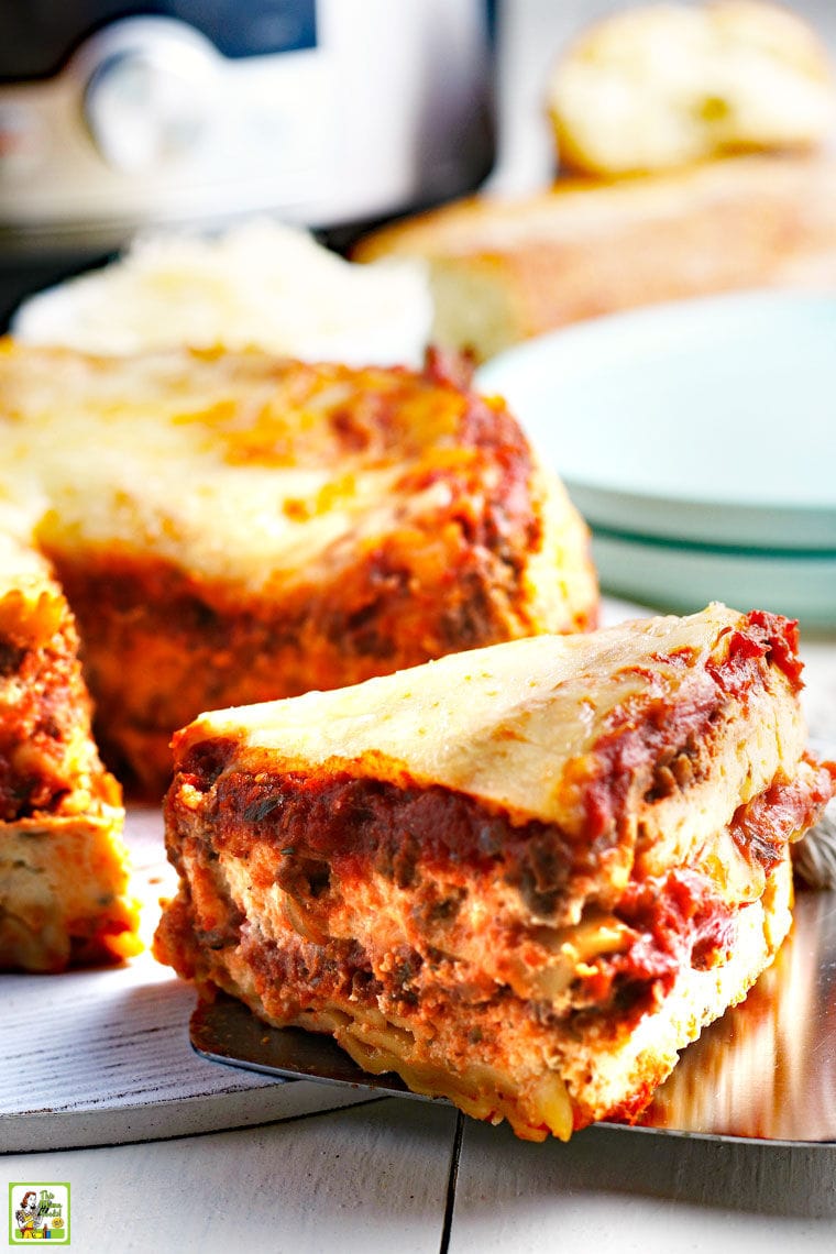Taking a slice out of lasagna with blue plates in the background.