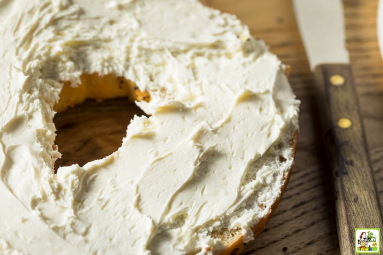 Closeup of a cream cheese covered bagel and a knife.