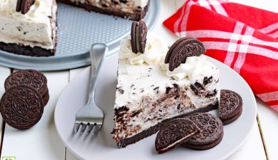 A plate of no bake Oreo cheesecake with a fork and a red napkin.