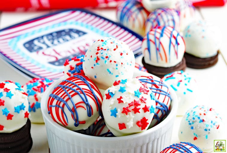 Red, white and blue Oreo cake balls in a bowl and with Oreos.