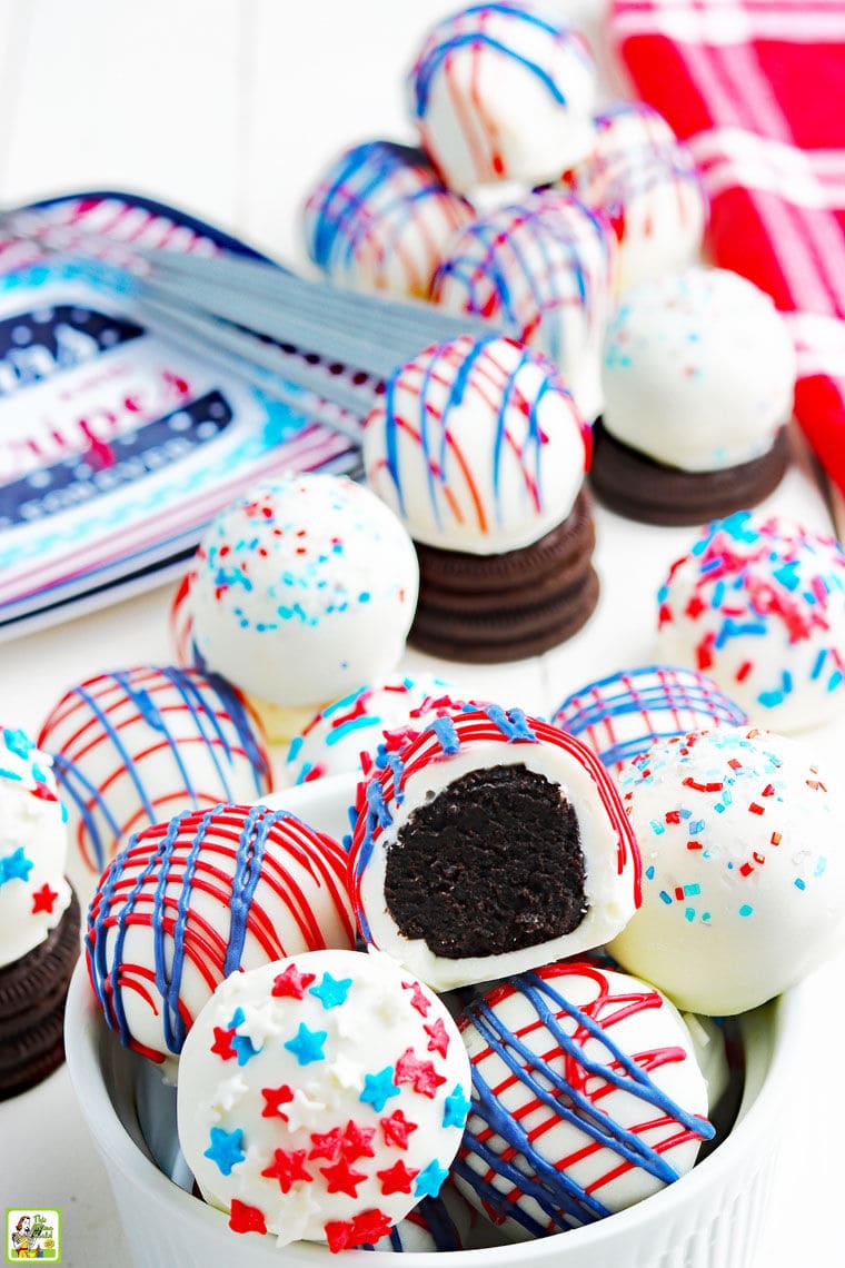 Holiday Oreo truffle balls in a bowl with a holiday paper plate, Oreos, and a red cloth napkin.