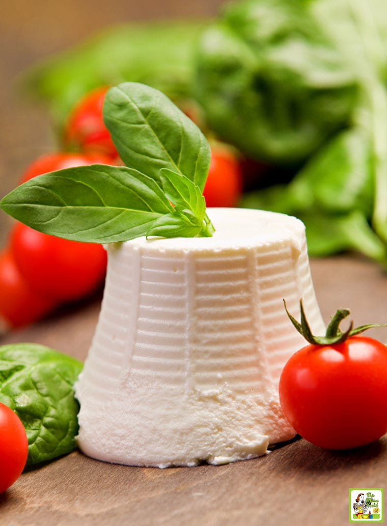A mound of ricotta with basil and tomatoes.