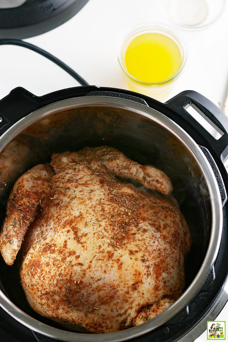A whole uncooked chicken in an open Instant Pot pressure cooker.