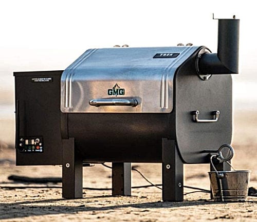 A black and silver Green Mountain Trek WiFi Controlled Portable Wood Pellet Tailgating Grill with side smoker box and chimney.