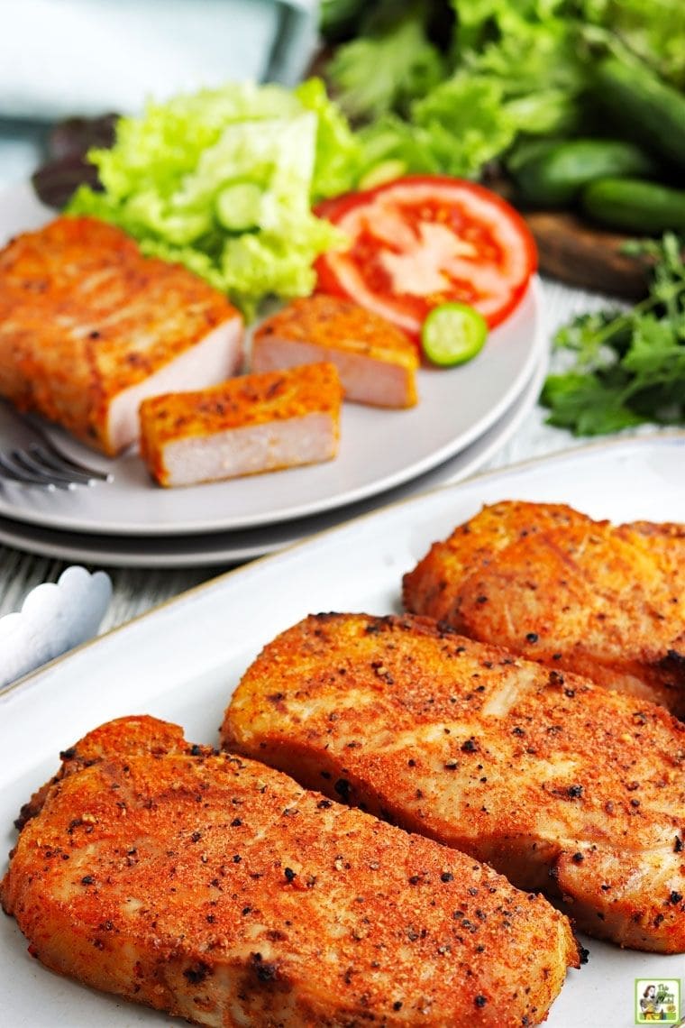 Platter of smoked pork chops with a plate of sliced pork chops with lettuce and tomato.